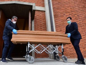 Pallbearers bring the coffin of deceased person to be stored into the church of San Giuseppe in Seriate, near Bergamo, Lombardy, on March 26, 2020, during the country's lockdown following the COVID-19 new coronavirus pandemic.