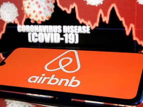 The Airbnb logo is seen in front of displayed coronavirus disease in this illustration taken March 19, 2020. (REUTERS/Dado Ruvic/Illustration/File Photo)