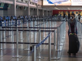 A passenger wears a face mask as a preventive measure against the spread of the new coronavirus, COVID-19, at Tocumen International Airport in Panama City on March 16, 2020. (LUIS ACOSTA/AFP via Getty Images)