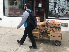 A man delivers Amazon packages following the spread of COVID-19 in the Manhattan borough of New York March 20, 2020. (REUTERS/Carlo Allegri)