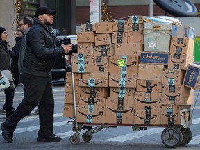 A delivery person pushes a cart full of Amazon boxes in New York City, Feb. 14, 2019.