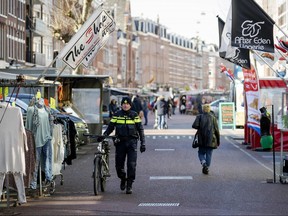 People walk through the Albert Cuypmarkt, on March 23, 2020 in Amsterdam. (ROBIN VAN LONKHUIJSEN/ANP/AFP via Getty Images)