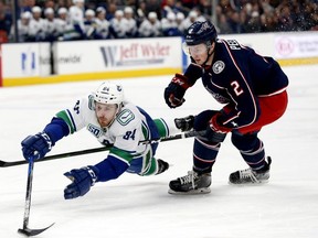 Vancouver Canucks centre Brandon Sutter reaches for the puck ahead of Columbus Blue Jackets defenseman Markus Nutivaara in the first period at Nationwide Arena.