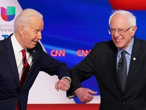 Democratic presidential hopefuls Joe Biden (left) and Bernie Sanders greet each other with a safe elbow bump before the start of their debate in Washington on March 15, 2020. (MANDEL NGAN/AFP via Getty Images)