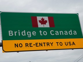 A "Bridge to Canada" sign is seen directing traffic to the Ambassador Bridge, during the coronavirus disease (COVID-19) outbreak, at the international border crossing, which connects with Windsor, Ontario, in Detroit, Michigan, U.S., March 18, 2020.      (REUTERS/Rebecca Cook)