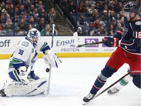 Vancouver Canucks' Louis Domingue, left, makes a save against Columbus Blue Jackets' Pierre-Luc Dubois during the second period of an NHL hockey game Sunday, March 1, 2020, in Columbus, Ohio.