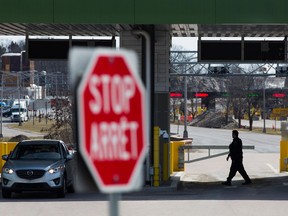 A border walks by a closed gate at the in Thousand Islands border, near Gananqoue, Ont., on Monday March 16, 2020.