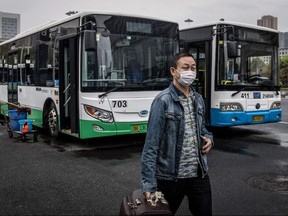 A man gets out of a bus in Wuhan in China's central Hubei province on Wednesday, March 25, 2020, after the public transportation partly resumed in the city.