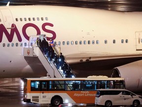 People board a plane chartered for British passengers after they left the coronavirus-hit cruise ship Diamond Princess at Haneda Airport, Tokyo Japan February 22, 2020.