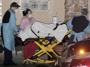 Medics transport a patient into an ambulance at the Life Care Center of Kirkland, the long-term care facility linked to several confirmed coronavirus cases in Washington state, in Kirkland, Wash., on Friday, March 6, 2020.
