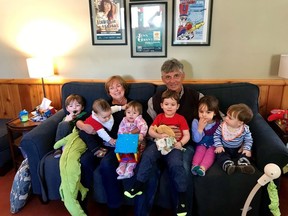 Catherine McLeod and her husband Paul Innes are seen in a March 2019 family handout photo surrounded by their grandkids. The couple are stuck on board a cruise ship where four people have died and several others have tested positive for COVID-19.