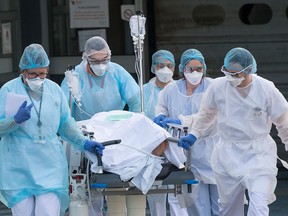 Medical staff push a patient on a gurney to a waiting medical helicopter at the Emile Muller hospital in Mulhouse, eastern France, to be evacuated on another hospital on March 17, 2020, amid the outbreak of the new Coronavirus, COVID-19.