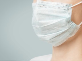 Unrecognizable woman in medical protective mask, close-up.