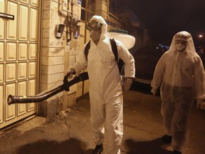 Iranian firefighters disinfect streets and alleys in southern Tehran to halt the wild spread of coronavirus on March 11, 2020. - The novel coronavirus outbreak in Iran is one of the deadliest outside of China and has so far killed 291 people and infected more than 8,000. (Photo by ATTA KENARE / AFP) (Photo by ATTA KENARE/AFP via Getty Images)