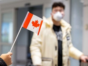 A traveller wears a mask at Pearson airport arrivals, shortly after Toronto Public Health received notification of Canada's first presumptive confirmed case of novel coronavirus, in Toronto, Jan. 26, 2020. (REUTERS/Carlos Osorio/File Photo)