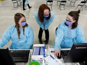 Medical staff members prepare to receive patients for coronavirus screening at a temporary assessment center at the Brewer hockey arena in Ottawa, March 13, 2020.  (REUTERS/Patrick Doyle)