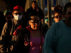 A man wearing a protective mask walks towards El Paso, Texas, U.S. at the international border bridge Paso del Norte, as seen from Ciudad Juarez, Mexico March 13, 2020.