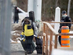 An asylum seeker crosses the border from New York into Canada followed by a Royal Canadian Mounted Police (RCMP) officer at Roxham Road in Hemmingford, Quebec, Canada March 18, 2020.