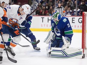 Vancouver Canucks goalie Thatcher Demko, right, stops New York Islanders' Anders Lee during the first period of an NHL hockey game in Vancouver, on Tuesday, March 10, 2020.