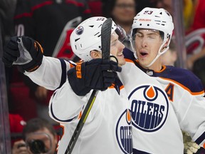 Edmonton Oilers right winger Josh Archibald  is congratulated by centre Ryan Nugent-Hopkins after his overtime goal against the Carolina Hurricanes at PNC Arena on Feb. 16, 2020.