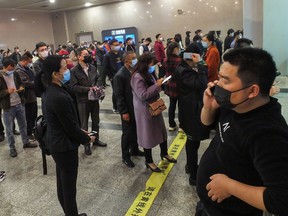 People queue to buy train tickets at Yichang East Railway Station in Yichang in China's central Hubei province on March 25, 2020. (STR/AFP via Getty Images)