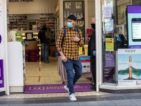 A man wears a face mask as a precautionary measure against COVID-19 as he exits a pharmacy in Dublin, on March 25, 2020. (PAUL FAITH/AFP via Getty Images)