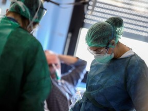 Medical staff wearing protective masks, glasses and suits treat patients suffering from coronavirus COVID-19 in an intensive care unit at the Oglio Po hospital in Cremona, Italy, Thursday, March 19, 2020.