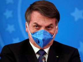 Brazil's President Jair Bolsonaro wears a protective face mask at a press statement during the COVID-19 outbreak in Brasilia, Brazil, March 20, 2020.