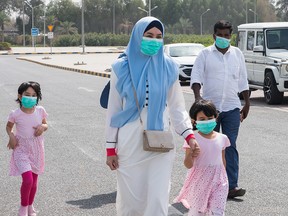 A family wear protective face masks, as they arrive at a makehsift coronavirus testing centre at the Mishref Fair Grounds in Kuwait city, Kuwait, on March 12, 2020.