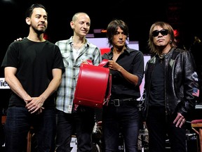 (L-R) Musicians Mike Shinoda and Chester Bennington of Linkin Park and Koshi Inaba and Tak Matsumoto of B'z pose with a childs backpack at a press conference to appear at a press conference to announce that fans raised over $350,000 to benefit Music For Relief in support of Save the Children in Japan at the Mayan Theatre on Aug. 31, 2011, in Los Angeles.