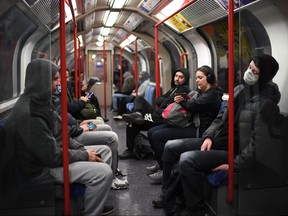 Commuters travel on the Central Line in London on the morning on March 24, 2020 after Britain ordered a lockdown to slow the spread of the novel coronavirus. (DANIEL LEAL-OLIVAS/AFP via Getty Images)