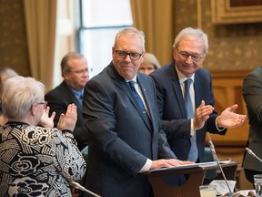 New Brunswick Finance Minister Ernie Steeves, centre, is applauded as he is about to deliver the provincial budget in the Legislature in Fredericton, N.B., on Tuesday, March 10, 2020. /Stephen MacGillivray