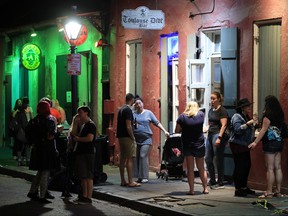People stand outside of a bar off of Bourbon Street on March 16, 2020 in New Orleans. (Chris Graythen/Getty Images)