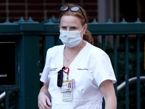 A nurse walks out of a hospital during the COVID-19 outbreak, in the Manhattan borough of New York City, Friday, March 27, 2020.