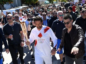 US actor Gerard Butler takes part in the Olympic flame torch relay for the Tokyo 2020 Summer Olympics.