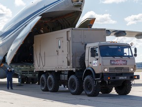 Russian servicemen load medical equipment and special disinfection vehicles into cargo planes while sending the supply to Italy at a military airdrome in Moscow March 22, 2020. (Russian Defence Ministry/Alexey Ereshko/Handout via REUTERS)
