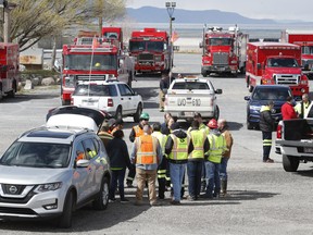 Salt Lake City firemen and other state emergency response team members wait at a staging area after Kennecott mining company experienced a chemical leak caused by an earthquake on March 18, 2020 in Magna, Utah. (George Frey/Getty Images)