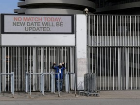 A man stands outside the San Siro stadium after the Inter Milan and Sampdoria Serie A match was cancelled due to an outbreak of the coronavirus, in Milan, Italy, on Feb. 23, 2020.