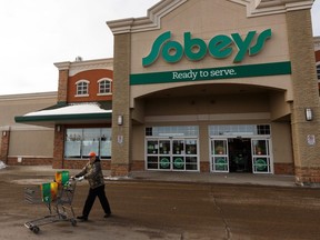 A customer pushes a cart of groceries at a Sobeys location in Edmonton, Tuesday, March 17, 2020.