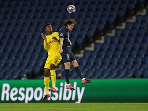 Borussia Dortmund's Dan Axel Zagadou battles with Paris St Germain's Edinson Cavani during Champions League play at Parc des Princes in Paris, Wednesday, March 11, 2020. (UEFA Pool/Handout via REUTERS)