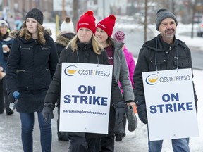 Teachers walk along Longfields Dr in Barrhaven as the OSSTF in Ottawa stage a one day strike. (Wayne Cuddington/Postmedia Network)