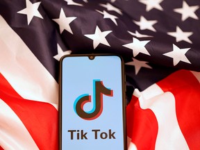 The Tik Tok logo is displayed on the smartphone while standing on the U.S. flag in this illustration picture taken, Nov. 8, 2019.