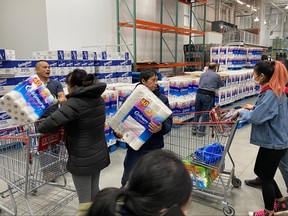 Workers ration toilet paper in an effort to stem hoarding due to fears of coronavirus, at a Costco store in Toronto March 14, 2020. (REUTERS/Chris Helgren)