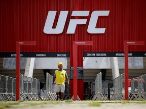 A man walks in front of the Nilson Nelson Gymnasium as the next UFC Fight Night will be held without fans in Brasilia, Brazil, March 12, 2020. (REUTERS/Adriano Machado)