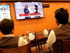 Afghans watch a live TV broadcast at a restaurant during an agreement signing ceremony between the United States and the Taliban in Kabul, Afghanistan, February 29, 2020.