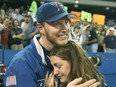 Hall of Fame pitcher Roy Halladay embraces his wife, Brandy, after winning his club-record 22nd game of the season during his days with the Toronto Blue Jays.