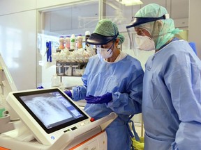 Medical staff wear their Personal Protective Equipment (PPE) as they look at the scan at the ASST Papa Giovanni XXIII hospital in Bergamo, Italy, on April 3, 2020. (AFP via Getty Images)