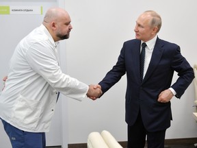 Russian President Vladimir Putin shakes hands with the hospital's chief physician Denis Protsenko during a visit to the hospital for patients, infected with coronavirus disease (COVID-19), on the outskirts of Moscow, Russia March 24, 2020. (Sputnik/Alexey Druzhinin/Kremlin/File Photo via REUTERS)