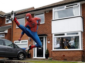 Jason Baird is seen dressed as Spiderman during his daily exercise to cheer up local children in Stockport, as the spread of the coronavirus disease (COVID-19) continues, Stockport, Britain, April 1, 2020. (REUTERS/Phil Noble)