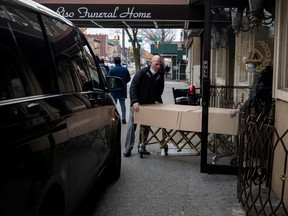 Men carry a body into a funeral home during the outbreak of the coronavirus disease (COVID-19) in New York City, U.S., April 5, 2020. (REUTERS/Jeenah Moon)